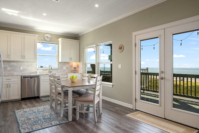 kitchen featuring stainless steel dishwasher, french doors, white cabinets, and a water view