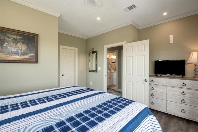 bedroom with crown molding, dark hardwood / wood-style floors, and connected bathroom