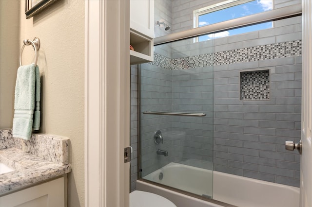 full bathroom with vanity, shower / bath combination with glass door, and toilet