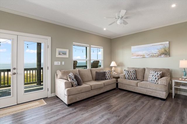 living room with crown molding, hardwood / wood-style floors, a water view, a textured ceiling, and french doors