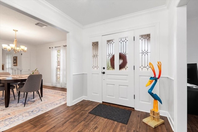 foyer featuring ornamental molding, a chandelier, and dark hardwood / wood-style flooring