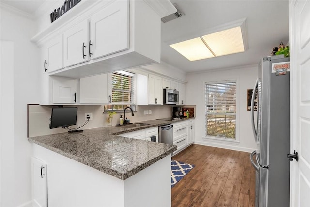 kitchen featuring stainless steel appliances, sink, white cabinets, and kitchen peninsula