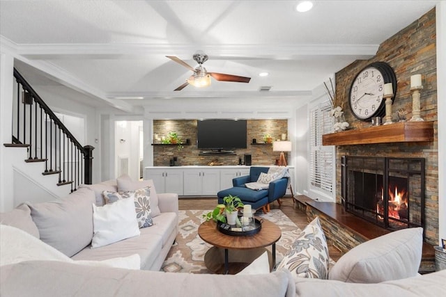 living room with crown molding, a fireplace, hardwood / wood-style floors, and beam ceiling