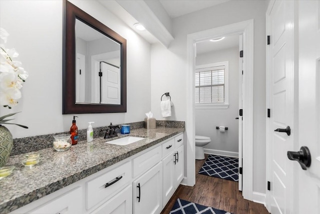 bathroom with wood-type flooring, toilet, and vanity