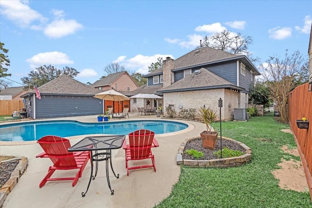 view of swimming pool featuring central AC unit, a yard, and a patio area