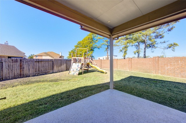 view of yard featuring a playground and a patio