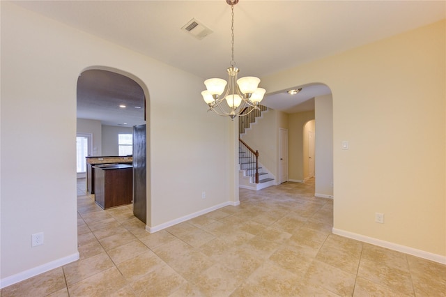 spare room featuring an inviting chandelier