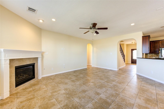 unfurnished living room featuring light tile patterned flooring, ceiling fan, and a tiled fireplace