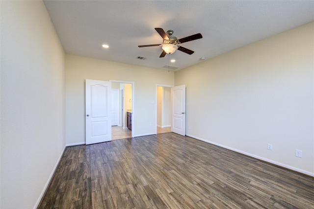 unfurnished bedroom with dark hardwood / wood-style flooring, ceiling fan, and ensuite bath