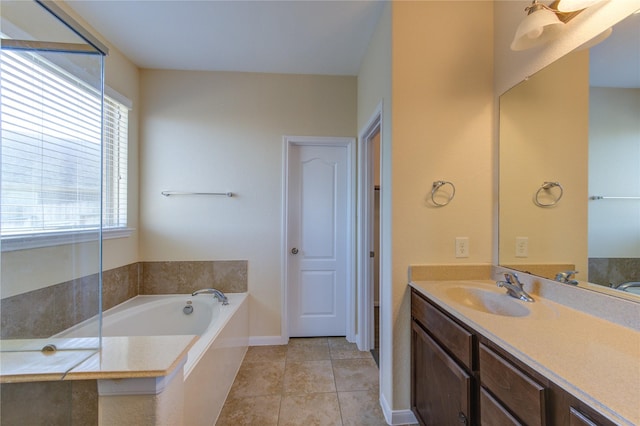 bathroom with tile patterned floors, tiled bath, and vanity