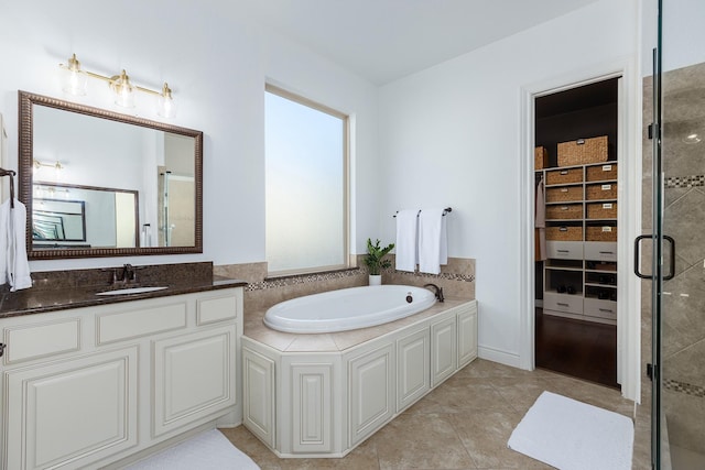 bathroom featuring tile patterned flooring, vanity, and separate shower and tub