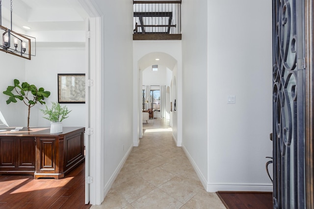 interior space with light tile patterned floors, a high ceiling, and a notable chandelier