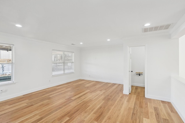 unfurnished room with ornamental molding and light wood-type flooring