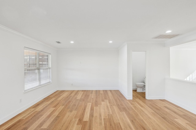 spare room with crown molding and light hardwood / wood-style flooring