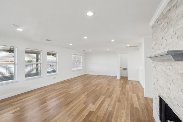 unfurnished living room featuring a fireplace, ornamental molding, and light hardwood / wood-style floors