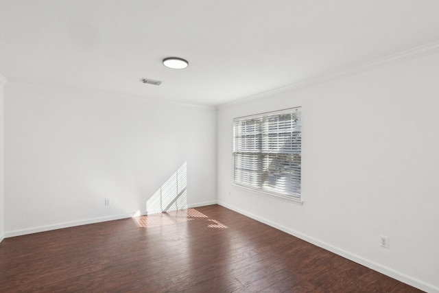 spare room featuring crown molding and dark wood-type flooring