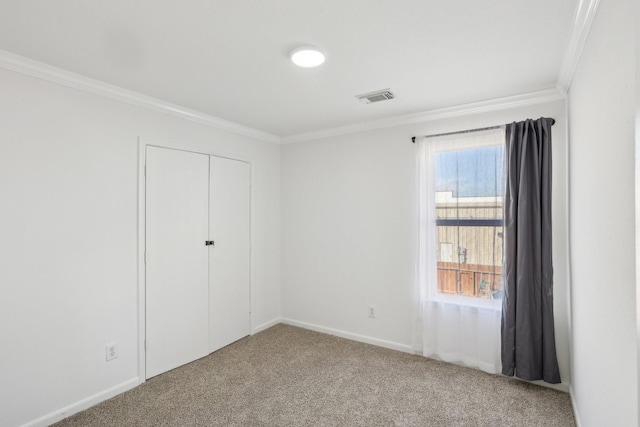 unfurnished bedroom featuring ornamental molding, carpet floors, and a closet