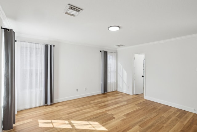 spare room featuring crown molding and hardwood / wood-style floors