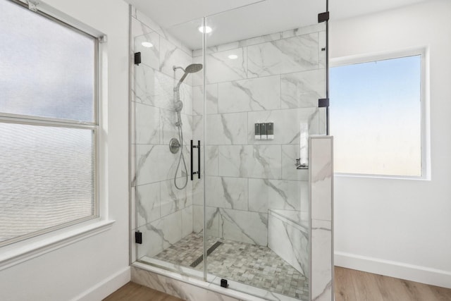 bathroom featuring hardwood / wood-style floors, a wealth of natural light, and walk in shower