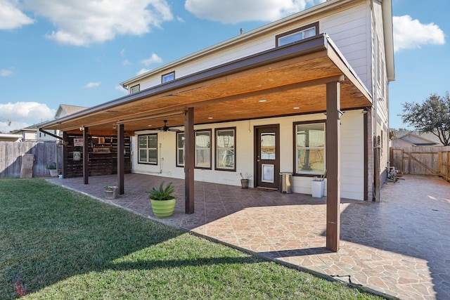 back of property featuring a lawn, ceiling fan, and a patio area