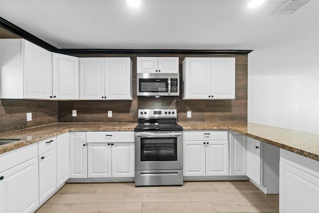 kitchen featuring light hardwood / wood-style flooring, stone counters, stainless steel appliances, tasteful backsplash, and white cabinets