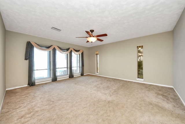 carpeted empty room featuring ceiling fan and a textured ceiling