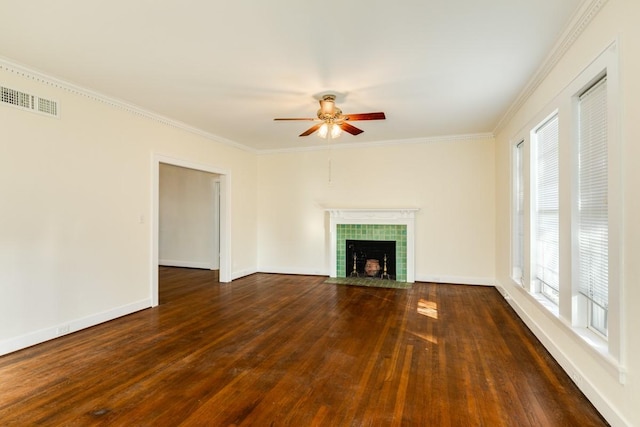 302 E Jackson St, West Columbia, TX 77486 - unfurnished living room featuring crown molding, dark hardwood / wood-style flooring, a tiled fireplace, and a wealth of natural light