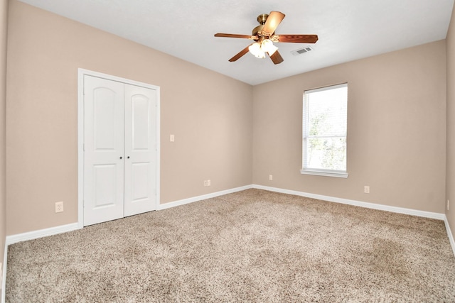 carpeted spare room with ceiling fan