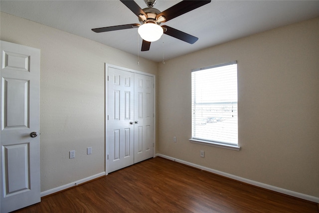 unfurnished bedroom featuring dark hardwood / wood-style floors, ceiling fan, and a closet