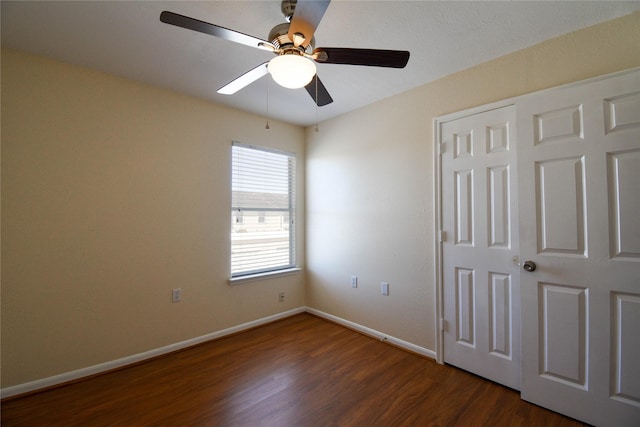 unfurnished bedroom featuring dark wood-type flooring, ceiling fan, and a closet