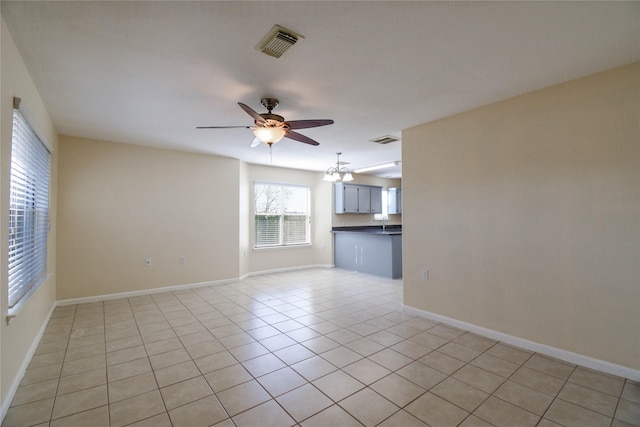 unfurnished living room with light tile patterned floors and ceiling fan