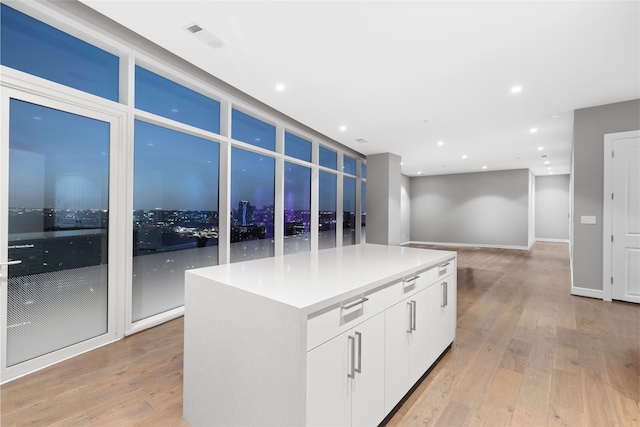 kitchen with light hardwood / wood-style floors, white cabinetry, and a center island