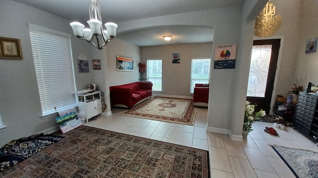 entryway with light tile patterned floors and a notable chandelier