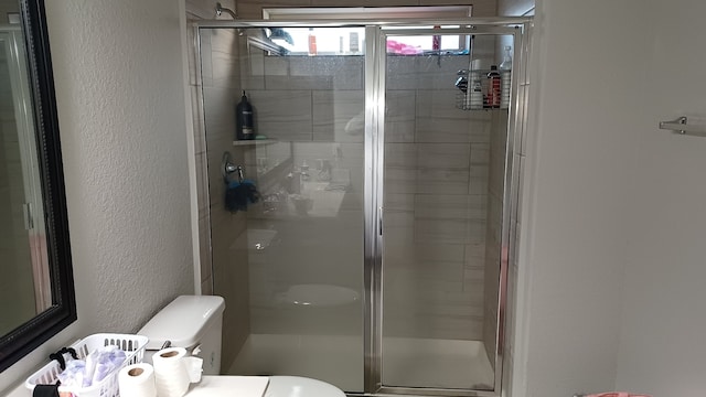 bathroom featuring toilet and an enclosed shower