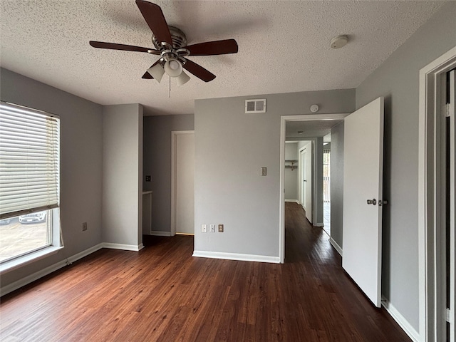 unfurnished bedroom with dark hardwood / wood-style flooring, multiple windows, and ceiling fan