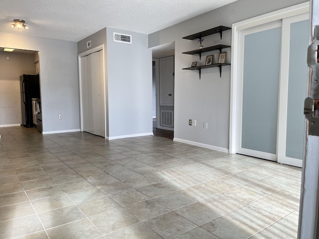 unfurnished room with a textured ceiling