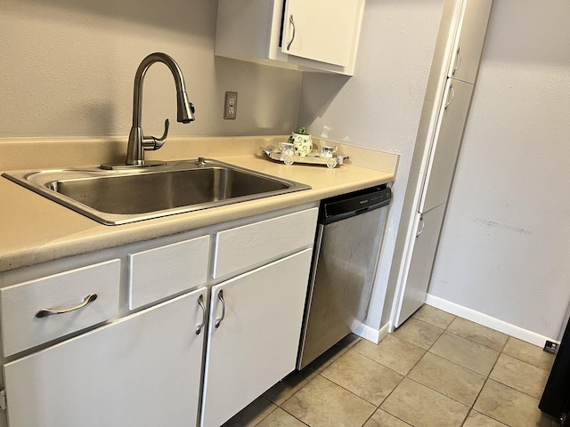 kitchen featuring white cabinetry, stainless steel dishwasher, sink, and light tile patterned floors