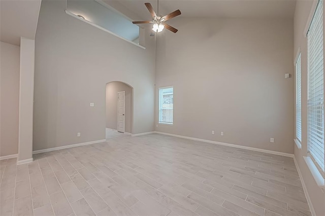 unfurnished room with ceiling fan, high vaulted ceiling, and light hardwood / wood-style flooring