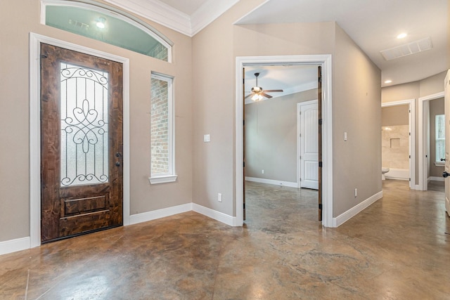 entryway with ornamental molding and concrete flooring