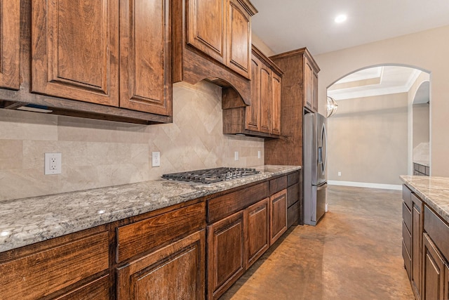 kitchen with light stone countertops, decorative backsplash, stainless steel appliances, and concrete floors