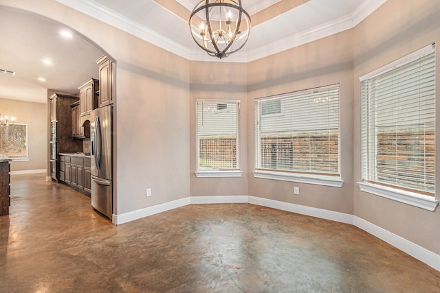 empty room featuring a notable chandelier, crown molding, and a raised ceiling