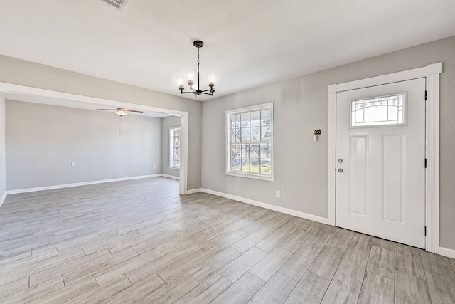 foyer featuring ceiling fan with notable chandelier