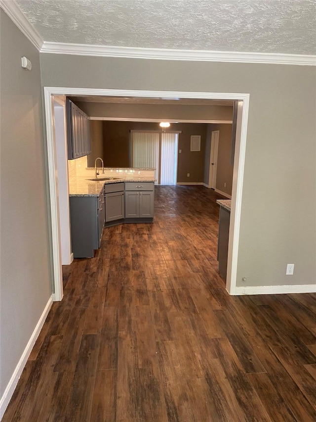 hall featuring sink, dark wood-type flooring, and a textured ceiling