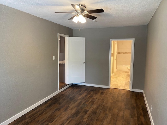 unfurnished bedroom with ceiling fan, dark hardwood / wood-style floors, and a textured ceiling