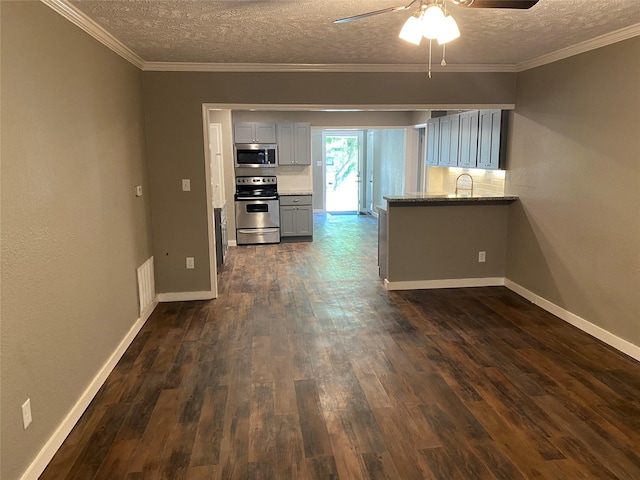 kitchen with sink, appliances with stainless steel finishes, gray cabinetry, ornamental molding, and kitchen peninsula