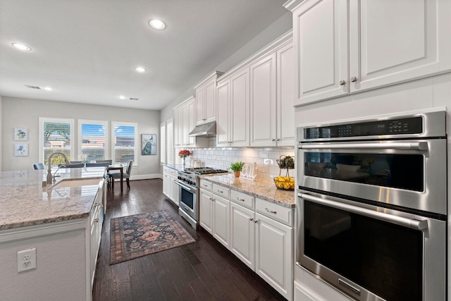 kitchen with stainless steel appliances, dark hardwood / wood-style floors, sink, and white cabinets