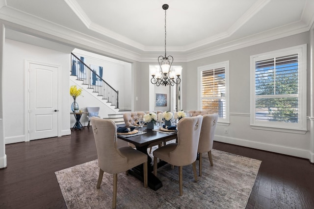 dining area with crown molding, a tray ceiling, dark hardwood / wood-style flooring, and an inviting chandelier