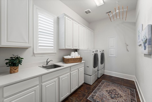 laundry area featuring cabinets, sink, and independent washer and dryer