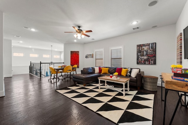 living room featuring dark wood-type flooring and ceiling fan