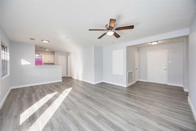 unfurnished living room with ceiling fan and light hardwood / wood-style flooring